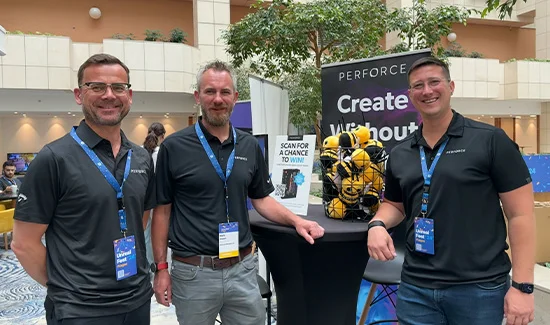 Three Perforce employees standing in front of a Perforce event banner