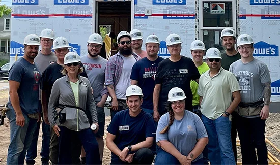 Perforce employees posing with hardhats after volunteering for Habitat for Humanity